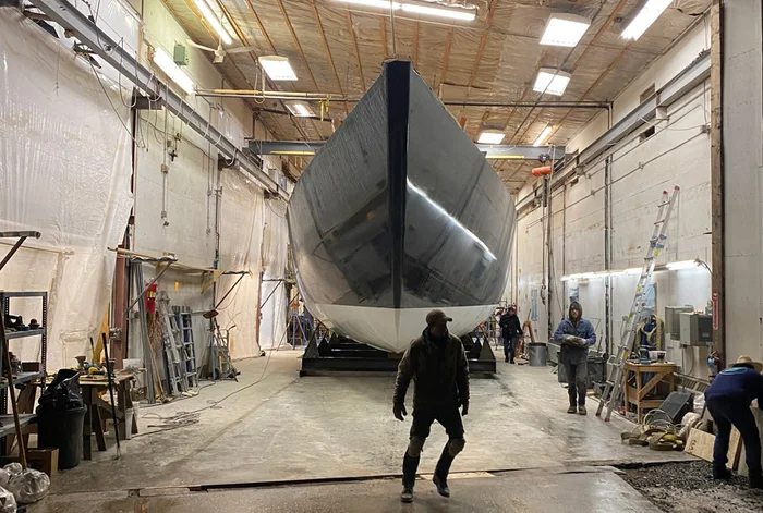 The hull seen bow-on inside the building shed after being turned upright.